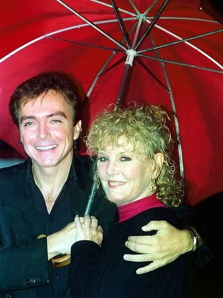 Petula Clark Singer and David Cassidy Singer standing together under a red umbrella
