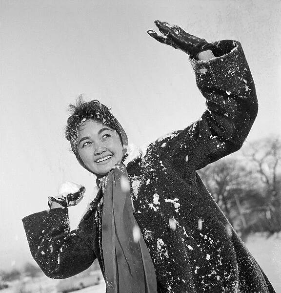 Philippine dancers have a snowball fight in London. One of the woman throwing