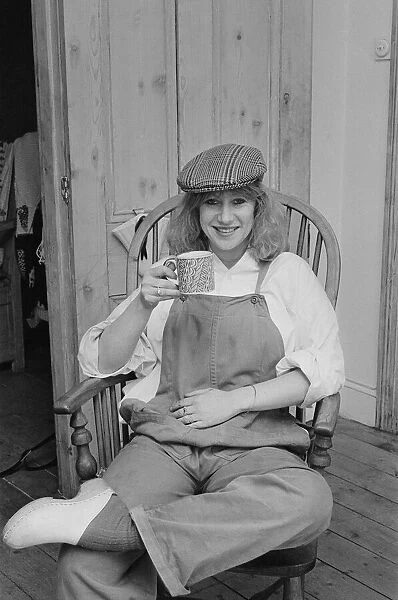 Photo shows Helen Mirren seated in her country Windsor chair wearing her favourite cap