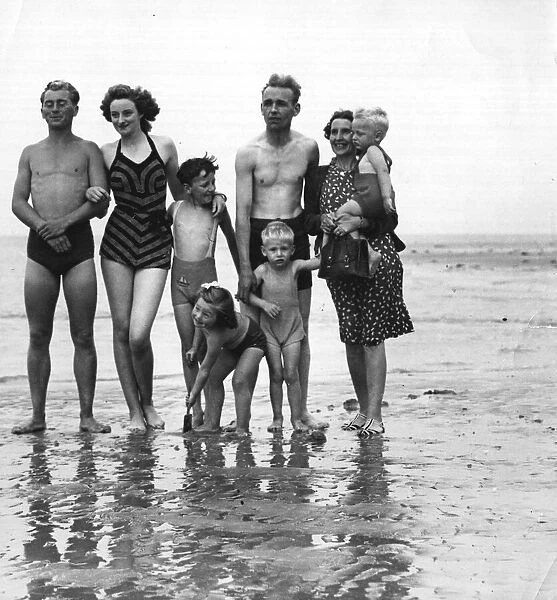 The photograph shows a family on the beach. September 1946 1940s