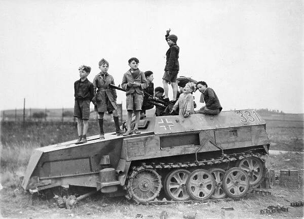 Picture shows children playing on a wrecked Nazi vehicle