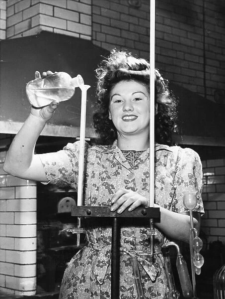 Picture shows Joyce Richardson, a munitions worker. She is pouring a liquid down a