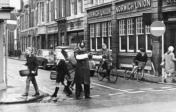 Picture shows a policeman on St Andrews Street, Cambridge, allowing traffic past