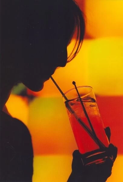 A picture of a woman drinking a cocktail enjoying a night out