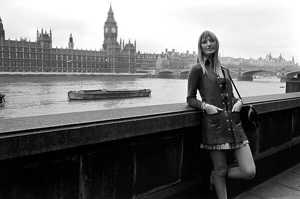 Places, London, England. A woman standing on the bank of the river Thames with