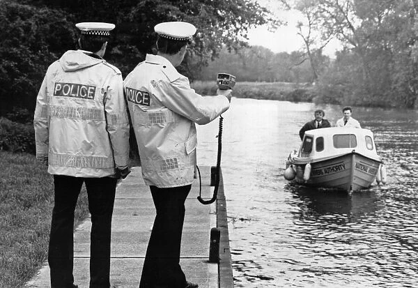 Police constable Ivan Jackson checks the speed of a passing boat along the River Cam