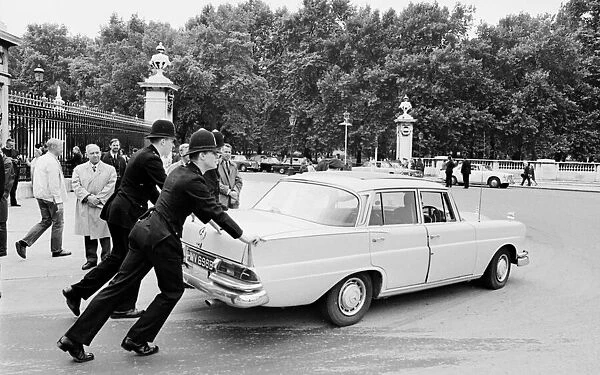 Police remove a Mercedes 200D car from in front of Buckingham Palace