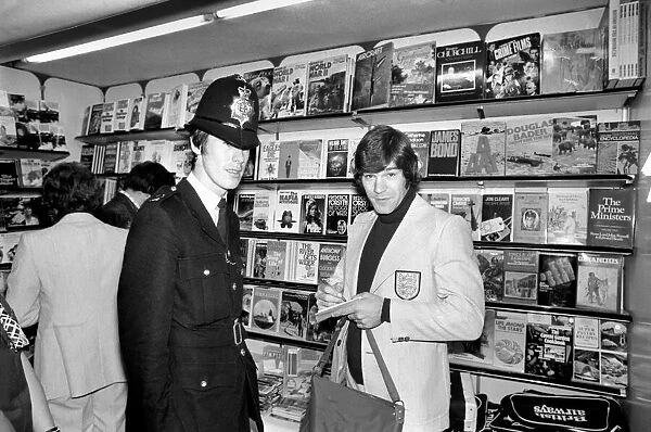 A policeman gets England footballer Malcolm MacDonalds autograph at Heathrow airport