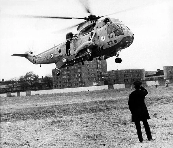 A policeman looks on as a RAF search and rescue Sea King helicopter from RAF Boulmer