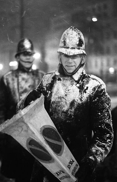 Policemen battle against a snow blizzard around Trafalgar Square London