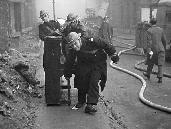 Policemen with a piano help salvage furniture following a V2 attack on Woodbine