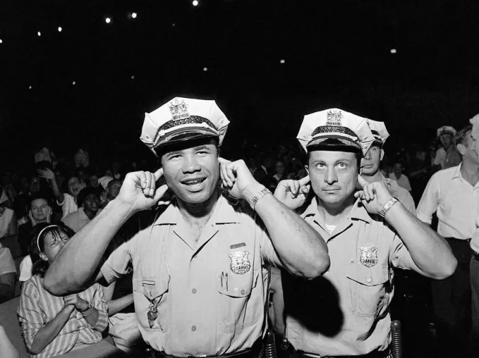 Framed Print : Two policemen try to block out the noise of the band playing Framed Print : Two policemen try to block out the noise of the band playing