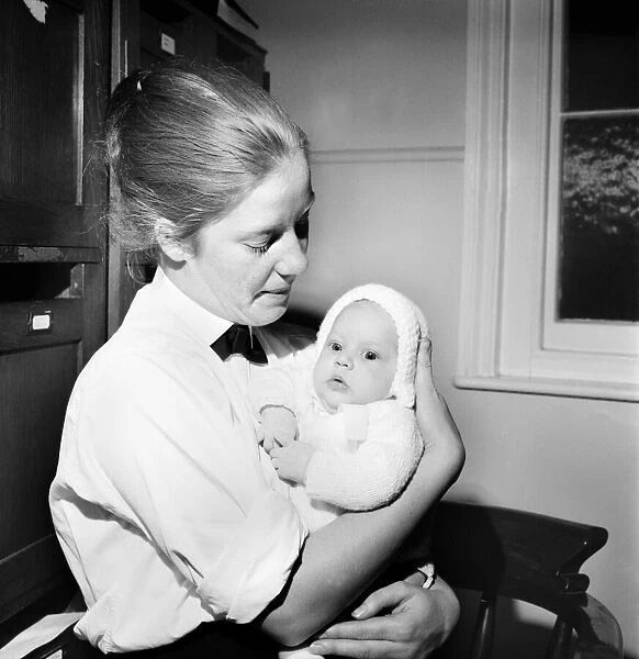 A policewoman holding a baby in her arms. October 1969 Z10514-001