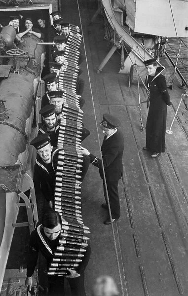 Pom Pom shells being passed to the platforms from the shell rooms by Royal Navy sailors