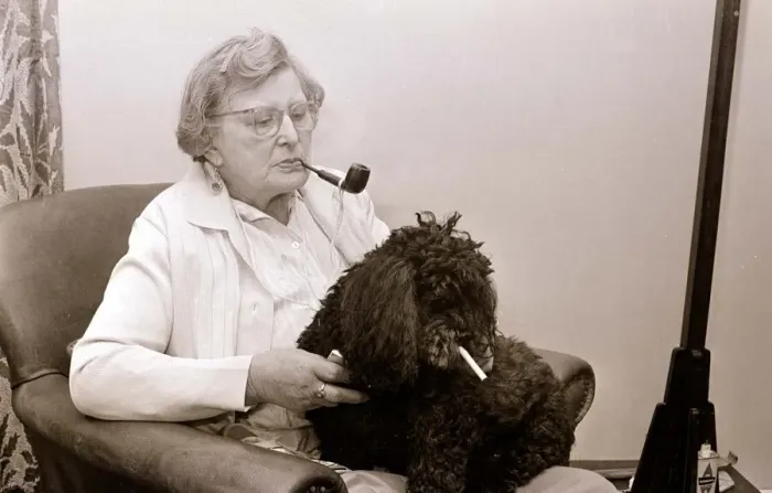 Framed Print : The Poodle who eats cigarettes An old lady smoking a pipe with her pet poodle who