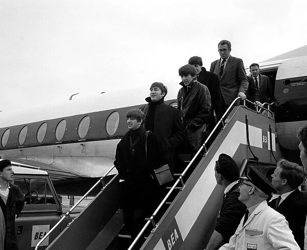 Pop Group The Beatles on the steps of their plane at London Airport