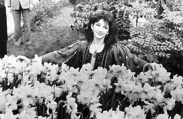 Pop singer Kate Bush poses in a garden full of daffodils, Tuesday 17th April 1979