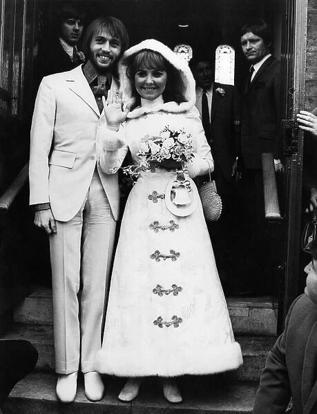 Pop singer Lulu wearing a maxi dress as she poses with the groom Maurice Gibb of the Bee