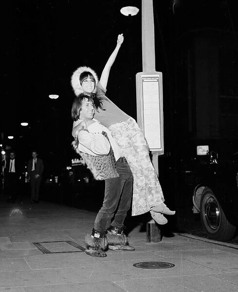 Pop singers Sonny and Cher wait for a bus outside the Hilton Hotel in London August