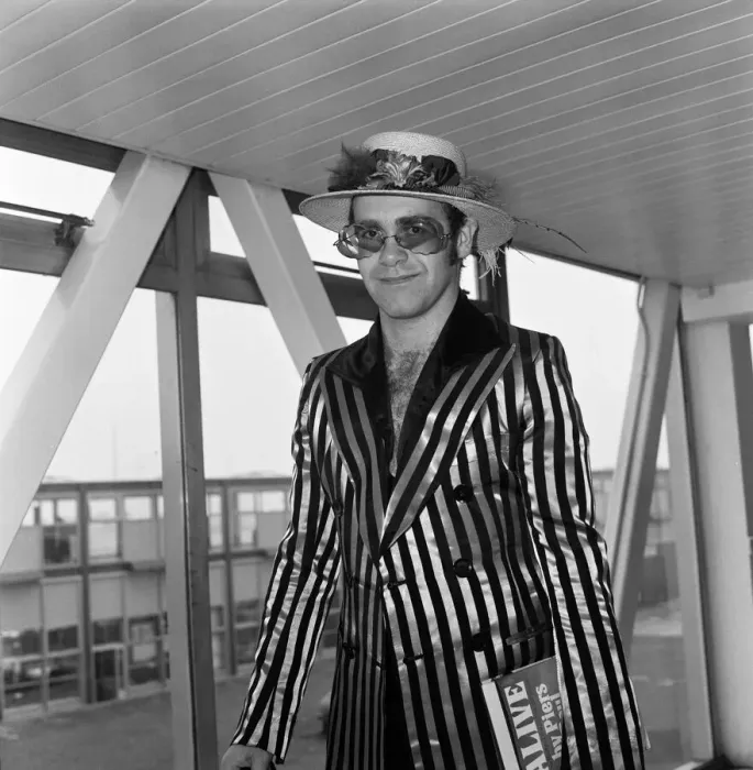 Framed Print : Pop star Elton John wearing a hat trimmed with flowers and feathers Framed Print : Pop star Elton John wearing a hat trimmed with flowers and feathers