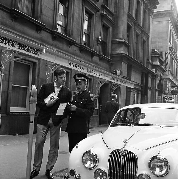 Pop star Marty Wilde, 22, is given a parking ticket after parking his cream Jaguar