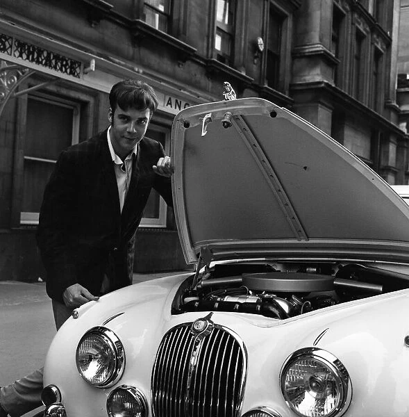 Pop star Marty Wilde, 22, is given a parking ticket after parking his cream Jaguar