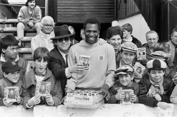 Framed Print : Pop star and Watford FC Chairman, Elton John, handing out Easter eggs to fans Framed Print : Pop star and Watford FC Chairman, Elton John, handing out Easter eggs to fans