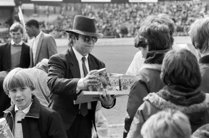 Framed Print : Pop star and Watford FC Chairman, Elton John, handing out Easter eggs to fans Framed Print : Pop star and Watford FC Chairman, Elton John, handing out Easter eggs to fans