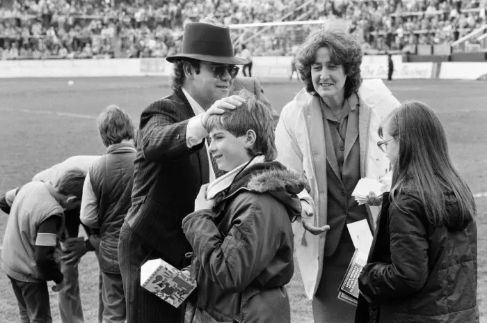 Framed Print : Pop star and Watford FC Chairman, Elton John, handing out Easter eggs to fans
