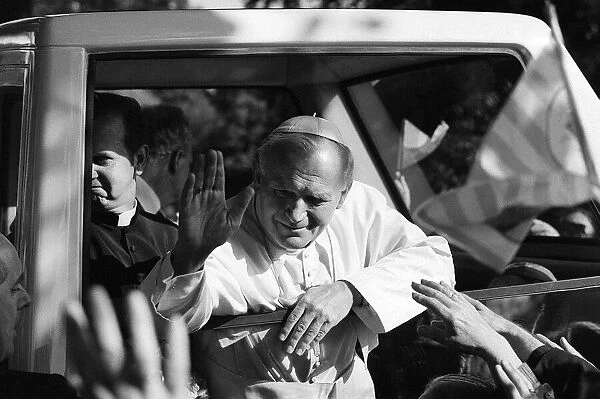 Pope John Paul II waves to the congregation from his pope mobile following an open air