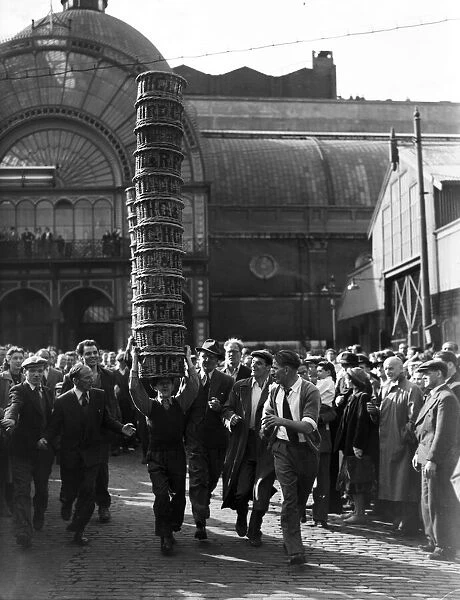 Porters from Covent Garden Flower and Vegetable market race with baskets stacked on their