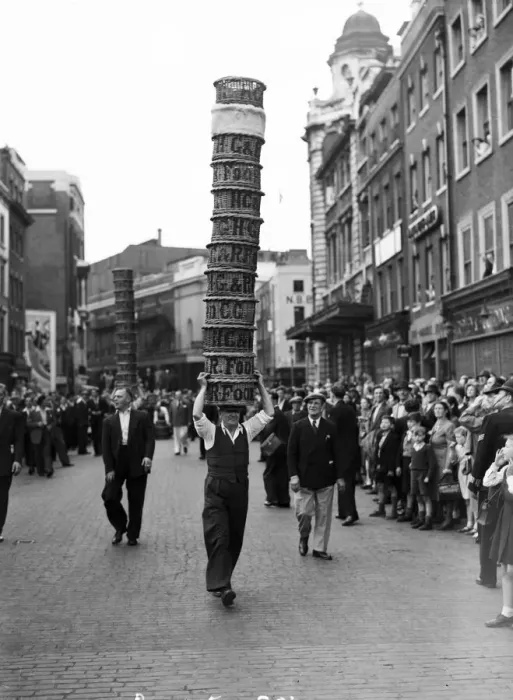 Framed Print : Porters from Covent Garden Flower and Vegetable market race with baskets stacked on their