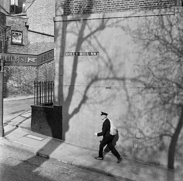 A postman walks along Holly Hill in Hampstead, North London. 8th April 1954