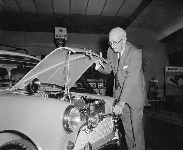 President of the British Motor Corporation Sir Leonard Lord inspects the engine of