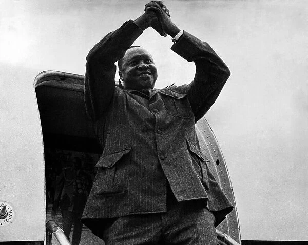 President of Uganda, General Idi Amin, waves goodbye as he boards his plane to return to