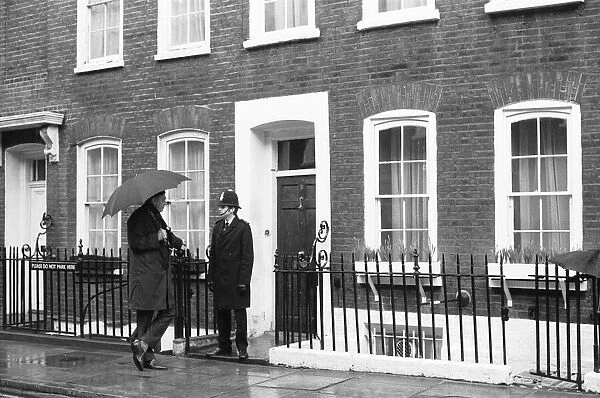 Press photographer chats with the police constable standing guard at the door to Harold