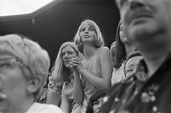 A pretty young Tennis Fan watches the Taylor v Drysdale match at Wimbledon Tennis