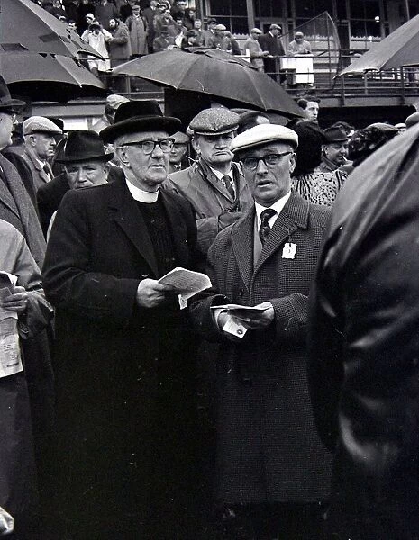 A priest holds his guide during a day out at the races in Cheltenham March 1963