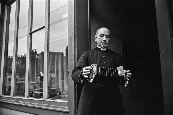 Framed Print : A priest plays a concertina outside Crabbs Concertina Shop in Liverpool Street