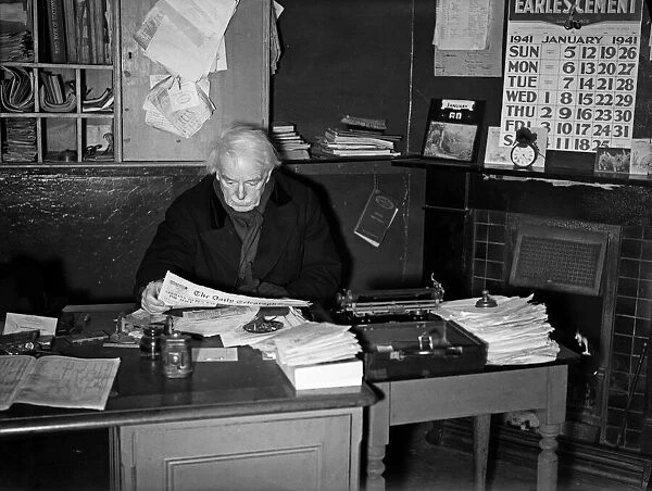Former Prime Minister David Lloyd George, sitting at a desk, reading the Daily Telegraph