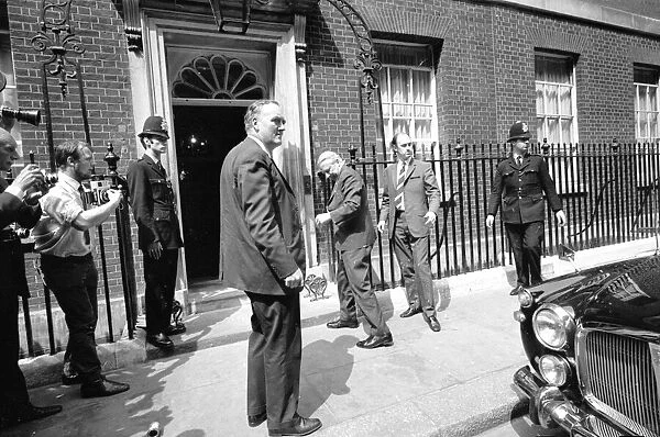 Prime Minister Edward Heath is rushed back inside Number 10 Downing Street watched by
