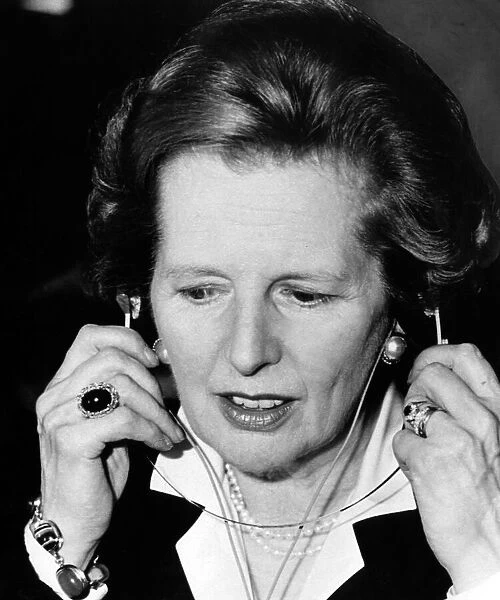 Prime Minister Margaret Thatcher tries out a pair of headphones - audio amplifiers - at