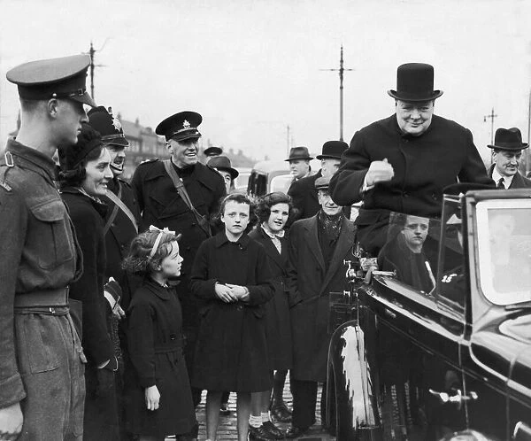 Prime Minister Winston Churchill sitting on the back of an open car on his surprise visit