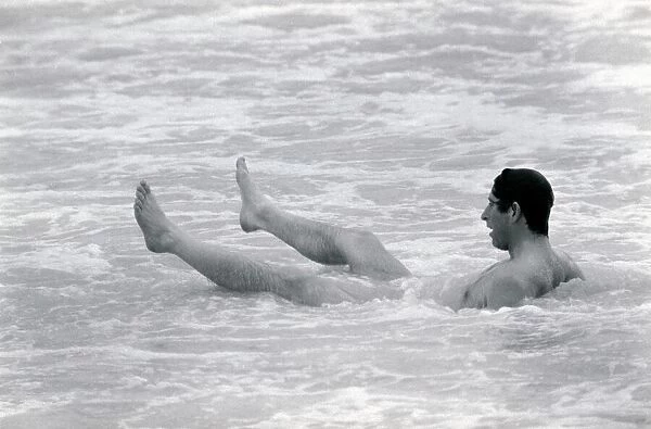 Prince Charles bathes of the coast of Australia. Prince of Wales sitting in