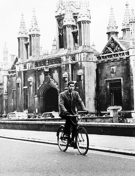 Prince Charles cycles past Kings College Cambridge