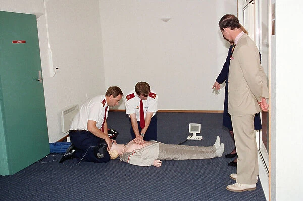 Prince Charles being demonstrated resuscitation techniques on an inflatable doll at an