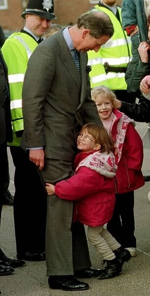 Prince Charles gets an unexpected hug from four year old Sarah Norris during a school