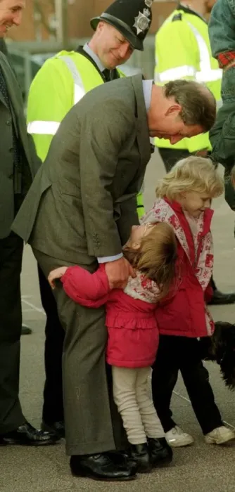 Framed Print : Prince Charles gets an unexpected hug from four year old Sarah Norris during a school