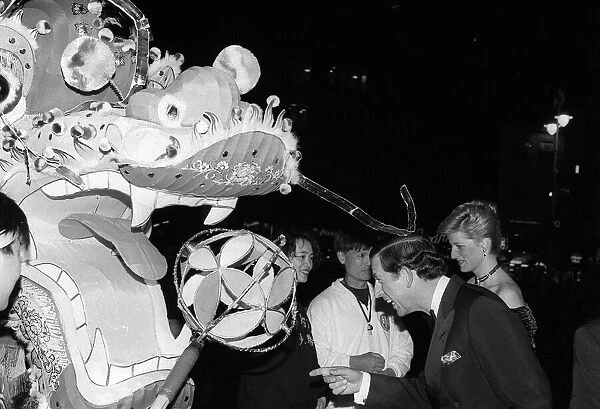 Prince Charles and Princess Diana observing a Chinese dragon as they attend the premier
