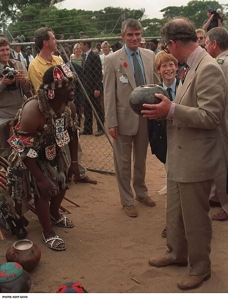 Prince Charles samples the native drink whilst his son Prince Harry watches on their